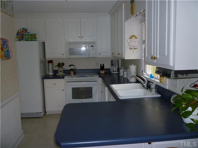 6424 Wynbrook Way Raleigh, NC 27612 - Photo 6 of 12 a kitchen with granite countertop a sink a stove a refrigerator and a cabinets