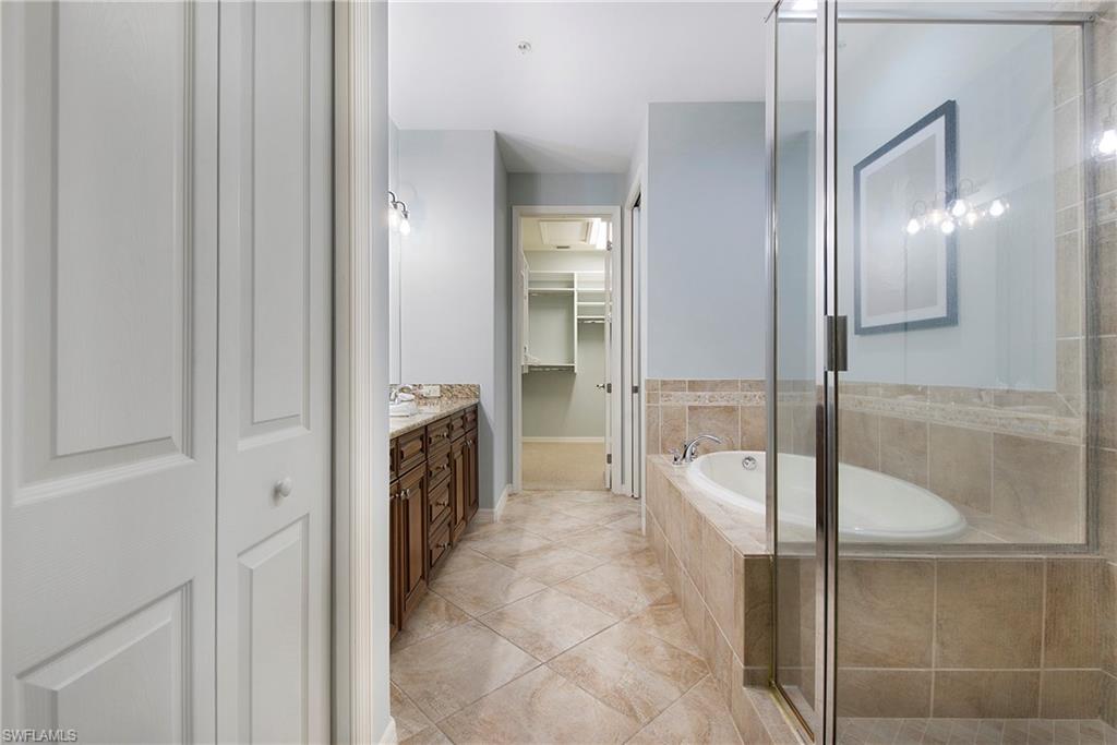 8975 Malibu Street, Unit 1304 Naples, FL 34113 - Photo 16 of 43 a bathroom with a tub and shower