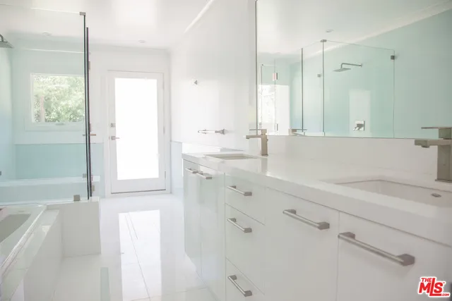 a bathroom with a tub sink and mirror