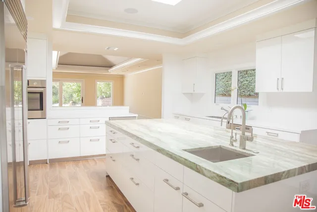 a kitchen with granite countertop a sink and a stove