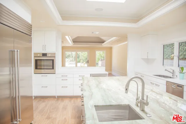 a view of a kitchen with granite countertop a stove a sink and a window