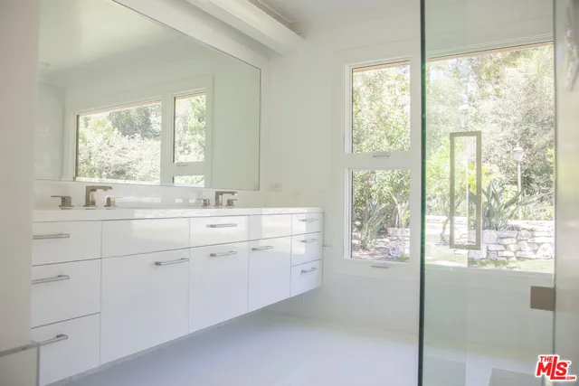 a spacious bathroom with double vanity and a window
