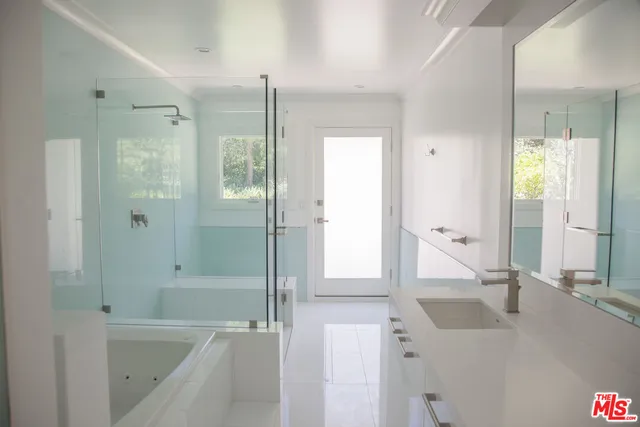 a bathroom with a tub sink and mirror