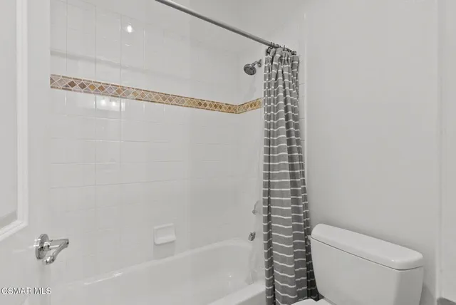 a bathroom with a granite countertop toilet sink and mirror