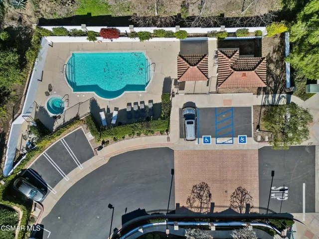an aerial view of a house with garden space and a car parked
