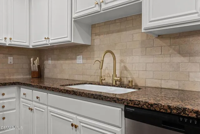 a kitchen with granite countertop a sink and cabinets