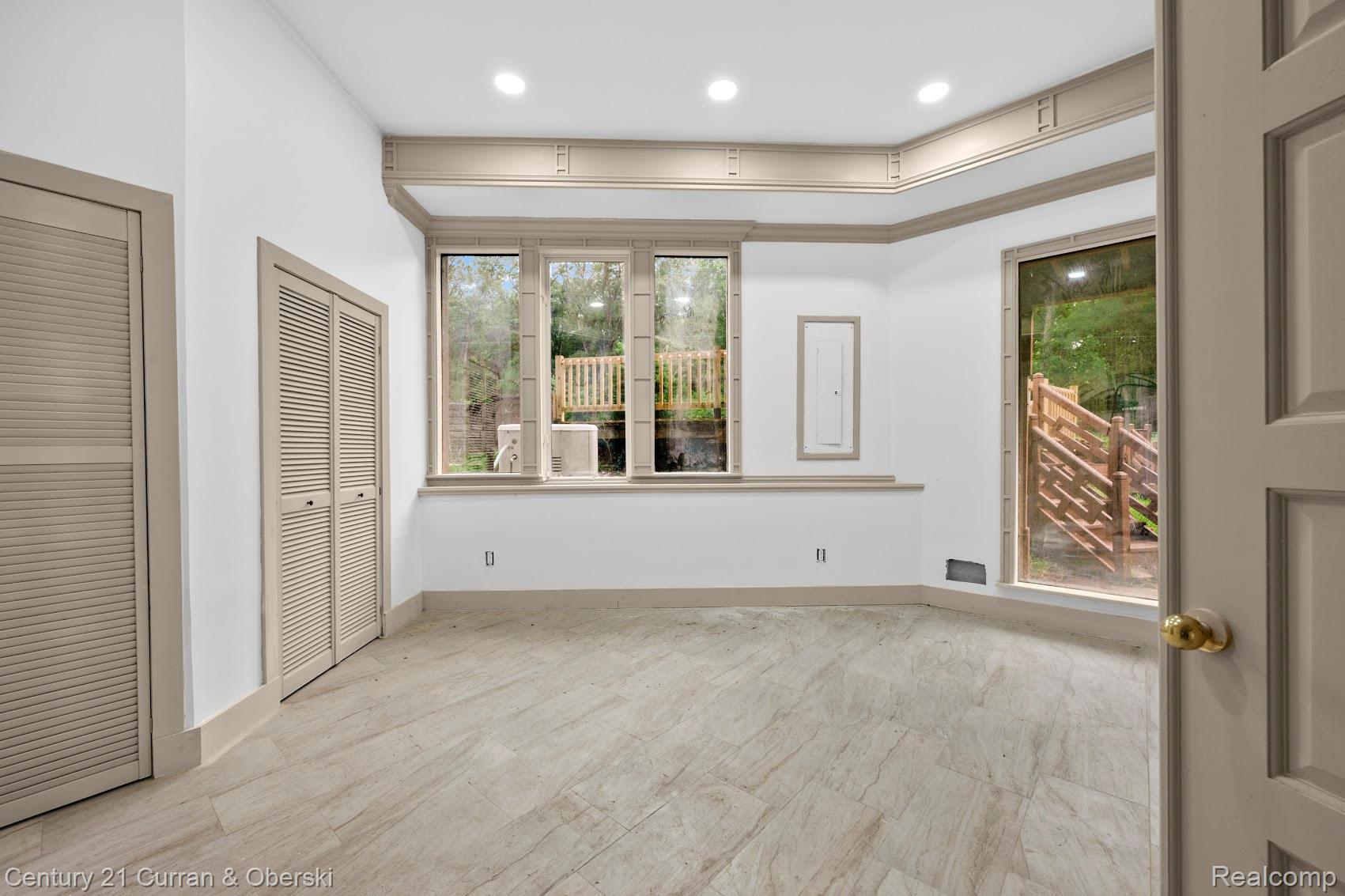 8785 Warren Road Plymouth, MI 48170 - Photo 30 of 46 Spacious room featuring large windows, recessed lighting, two louvered bifold closet doors, and wood-finish flooring