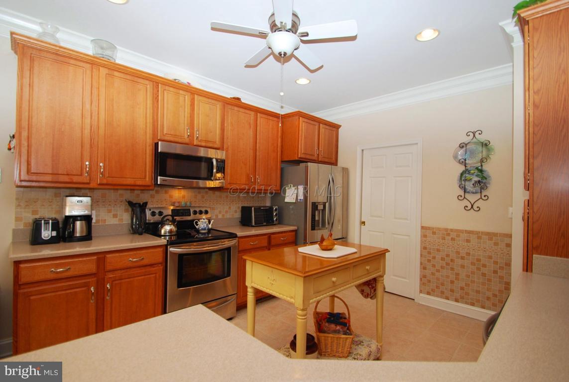 51 Pinehurst Road Ocean Pines, MD 21811 - Photo 12 of 50 a kitchen with stainless steel appliances kitchen island granite countertop a refrigerator a stove top oven a sink dishwasher and wooden cabinets