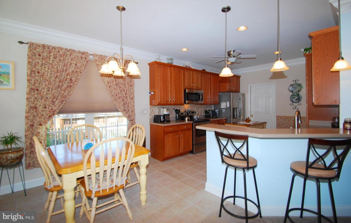 51 Pinehurst Road Ocean Pines, MD 21811 - Photo 15 of 50 a kitchen with stainless steel appliances a dining table chairs and a chandelier