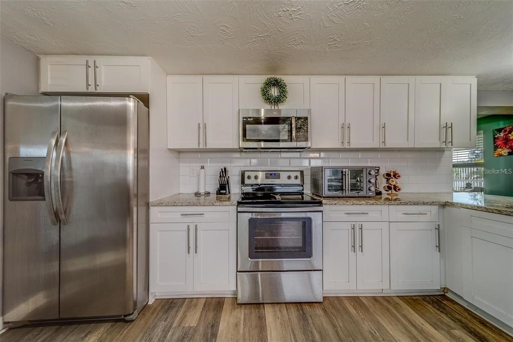 2646 Albion Street Holiday, FL 34691 - Photo 12 of 64 a kitchen with stainless steel appliances granite countertop a refrigerator sink and stove