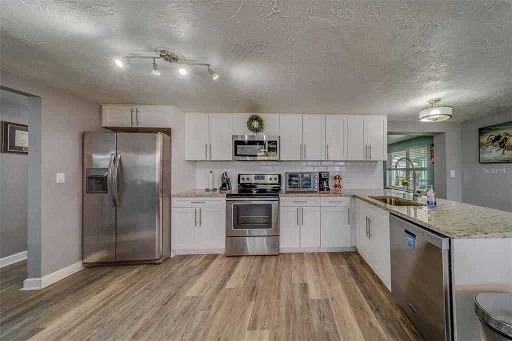 2646 Albion Street Holiday, FL 34691 - Photo 2 of 64 a kitchen with granite countertop a refrigerator stove top oven and sink