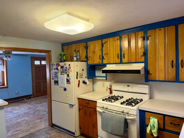 a kitchen with a stove a refrigerator and a window