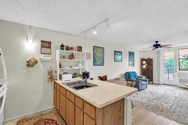a kitchen that has a cabinets a stove a dining table and chairs in it