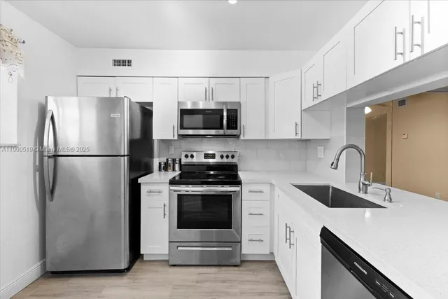 a kitchen with stainless steel appliances a refrigerator stove and microwave