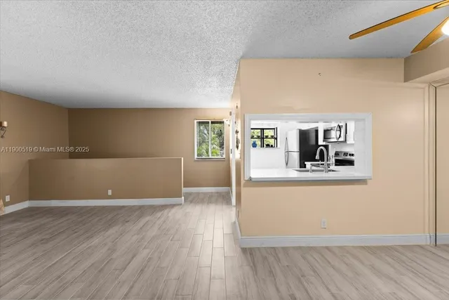 a view of a living room a kitchen with wooden floor and furniture