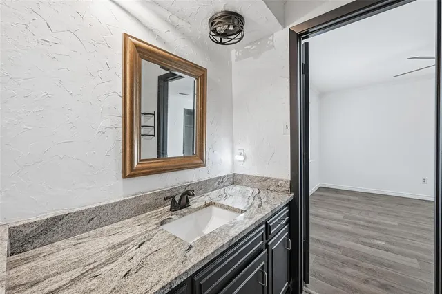 a bathroom with a granite countertop sink and a mirror
