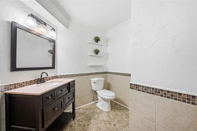 a bathroom with a toilet sink and mirror