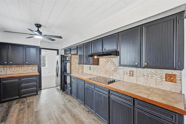 a kitchen with stainless steel appliances granite countertop a sink a stove and a refrigerator