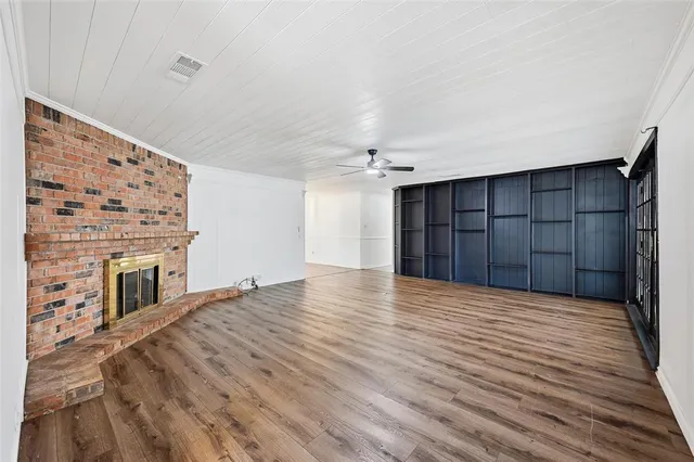 a view of an empty room with a fireplace and a window