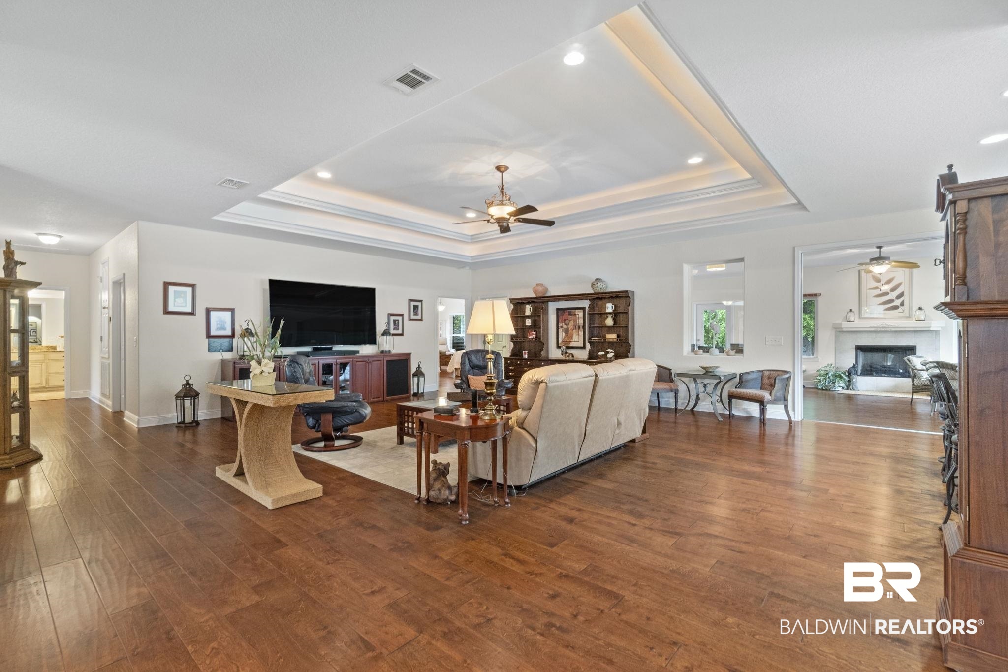 8664 Foxtail Loop Pensacola, FL 32526 - Photo 11 of 64 Living room with a raised ceiling, a ceiling fan, wood finished floors, a glass covered fireplace, and recessed lighting