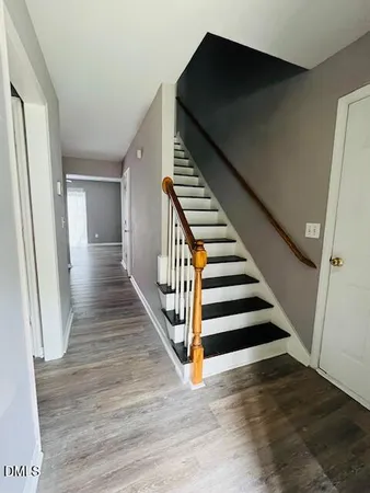 a view of a hallway with wooden floors and stairs