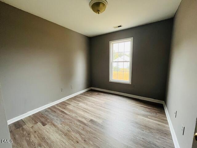 5419 Gunnette Drive Raleigh, NC 27610 - Photo 10 of 14 an empty room with wooden floor and windows