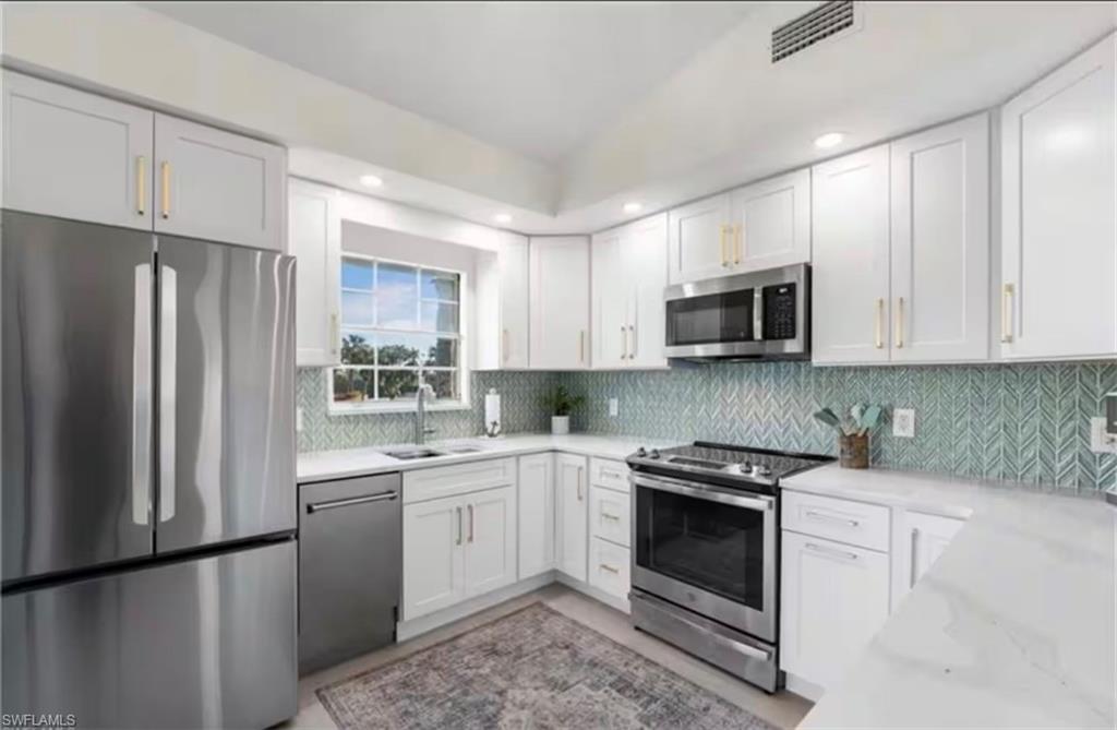 14993 Rivers Edge Court, Unit 246 Fort Myers, FL 33908 - Photo 1 of 23 a kitchen with white cabinets stainless steel appliances and sink