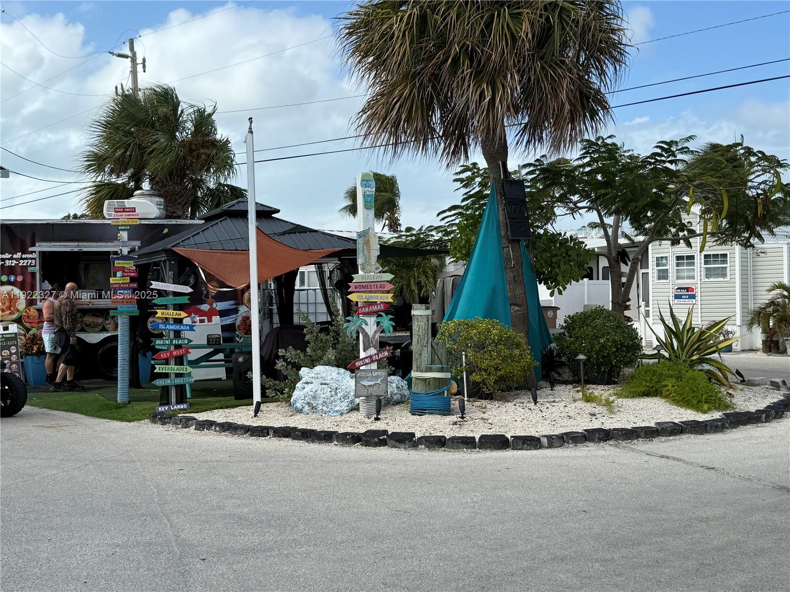 325 Calusa Street Key Largo, FL 33037 - Photo 16 of 25 a front view of a building with small garden