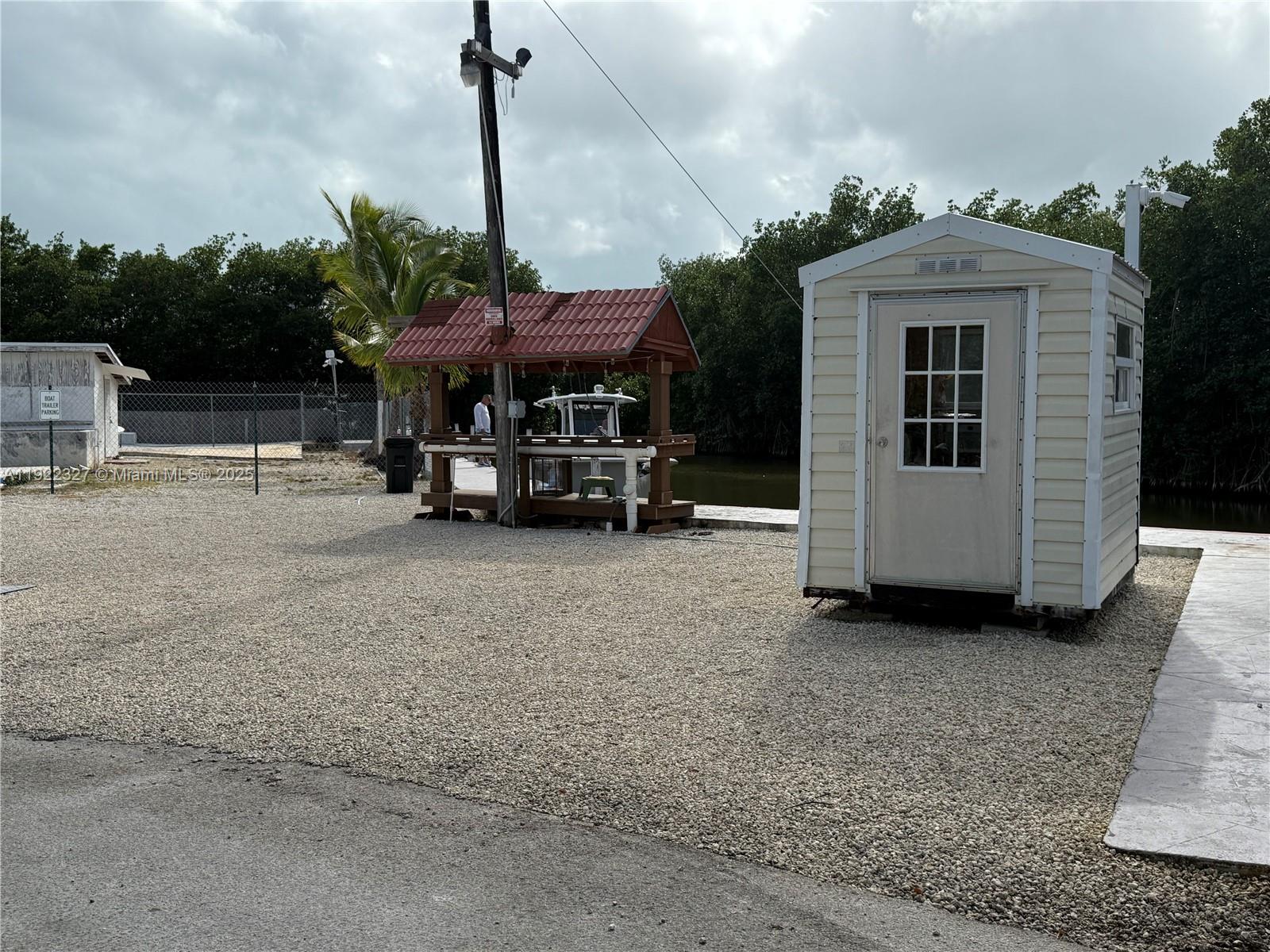 325 Calusa Street Key Largo, FL 33037 - Photo 22 of 25 a view of a house with a barbeque and large trees