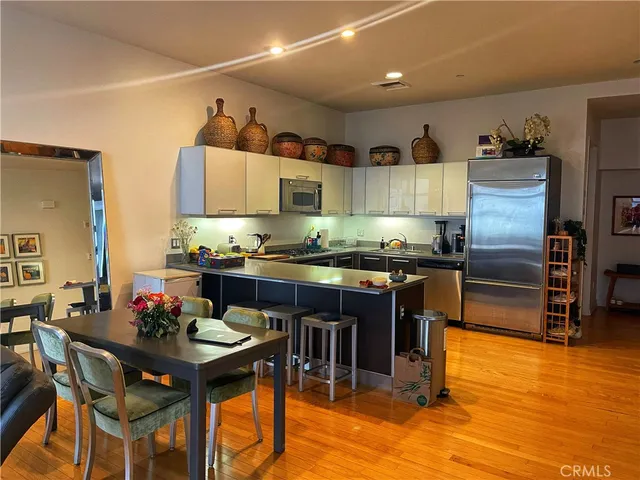 a kitchen with granite countertop a table chairs stove and refrigerator