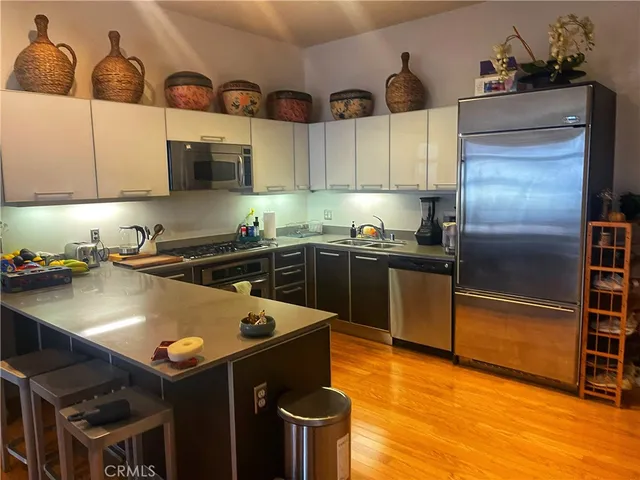 a kitchen with stainless steel appliances granite countertop a sink a stove and refrigerator