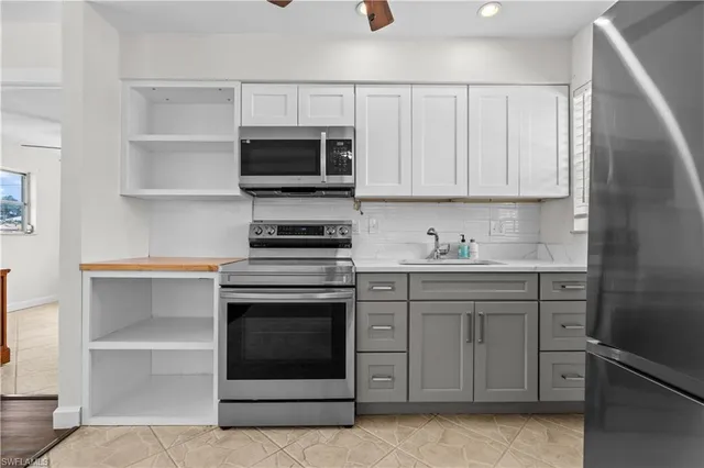 a kitchen with white cabinets stainless steel appliances and sink