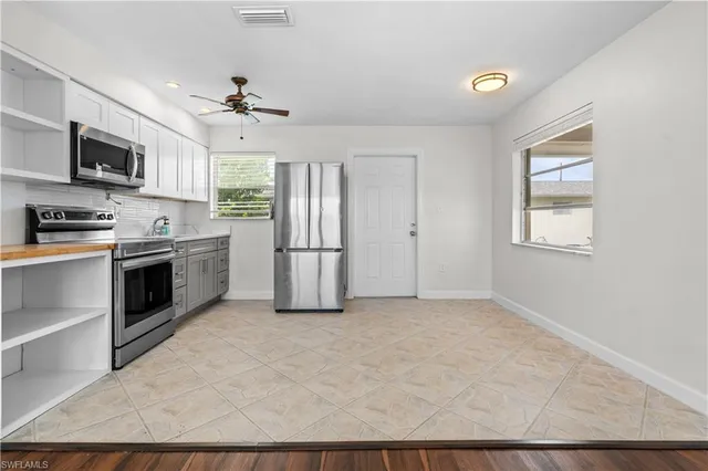 a view of a kitchen with a sink cabinet microwave and refrigerator