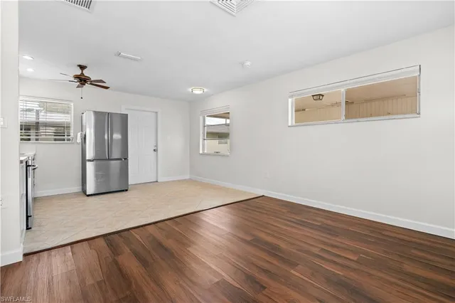 a view of empty room with wooden floor and window
