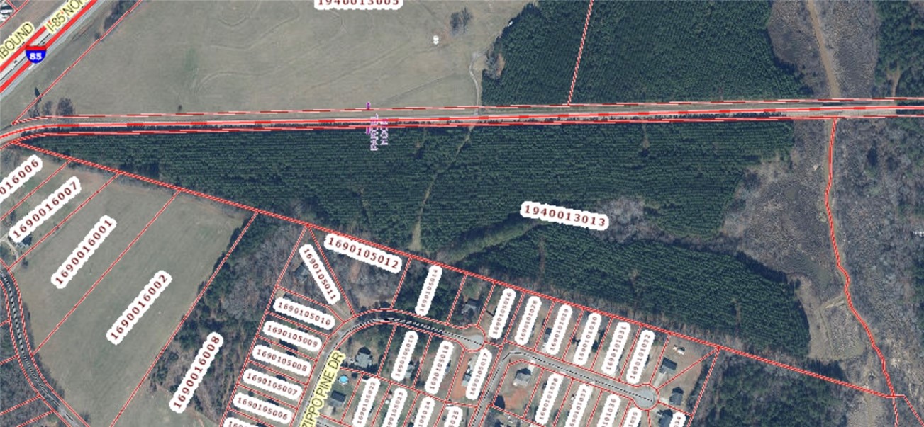 0 Hembree Road Williamston, SC 29697 - Photo 1 of 1 An aerial view captures the layout of multiple land parcels adjacent to a developed residential area and a highway.