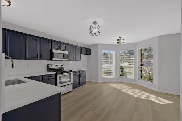 a kitchen with stainless steel appliances granite countertop a stove a sink dishwasher and a refrigerator with wooden cabinets