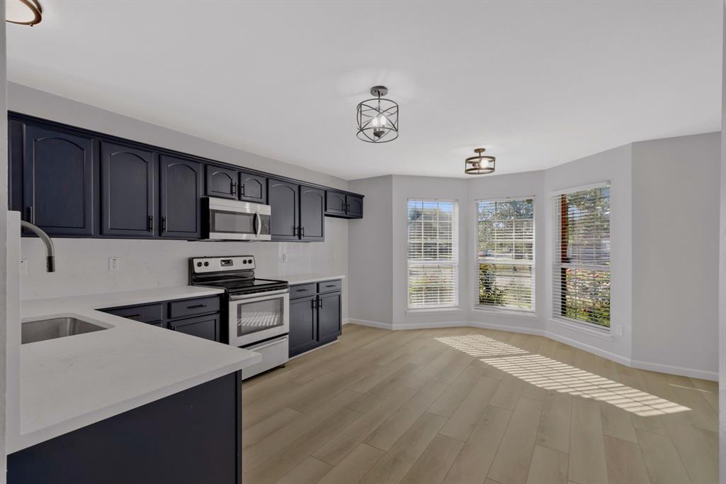 4172 Freedom Lane Frisco, TX 75033 - Photo 11 of 28 a kitchen with stainless steel appliances granite countertop a stove a sink dishwasher and a refrigerator with wooden cabinets