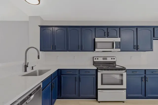 a kitchen with sink a microwave and cabinets