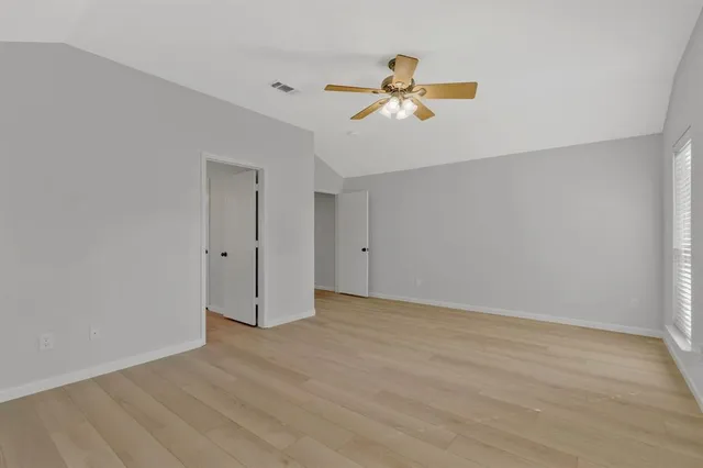 a view of a livingroom with a ceiling fan and wooden floor