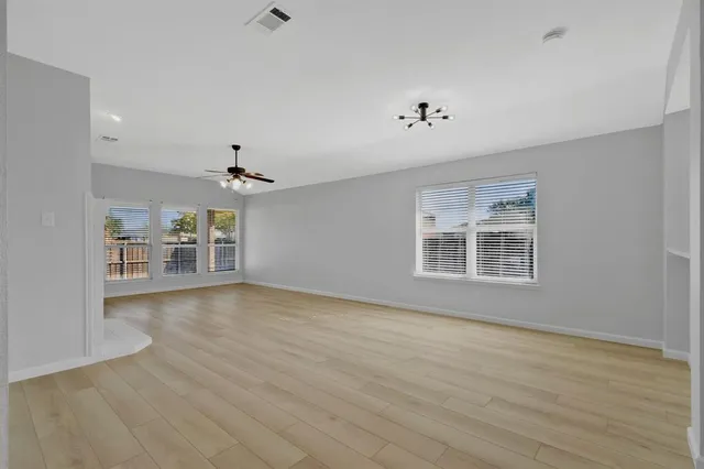 a view of a livingroom with a ceiling fan window and hardwood floor