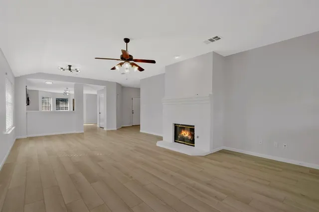 a view of an empty room with a fireplace and a window