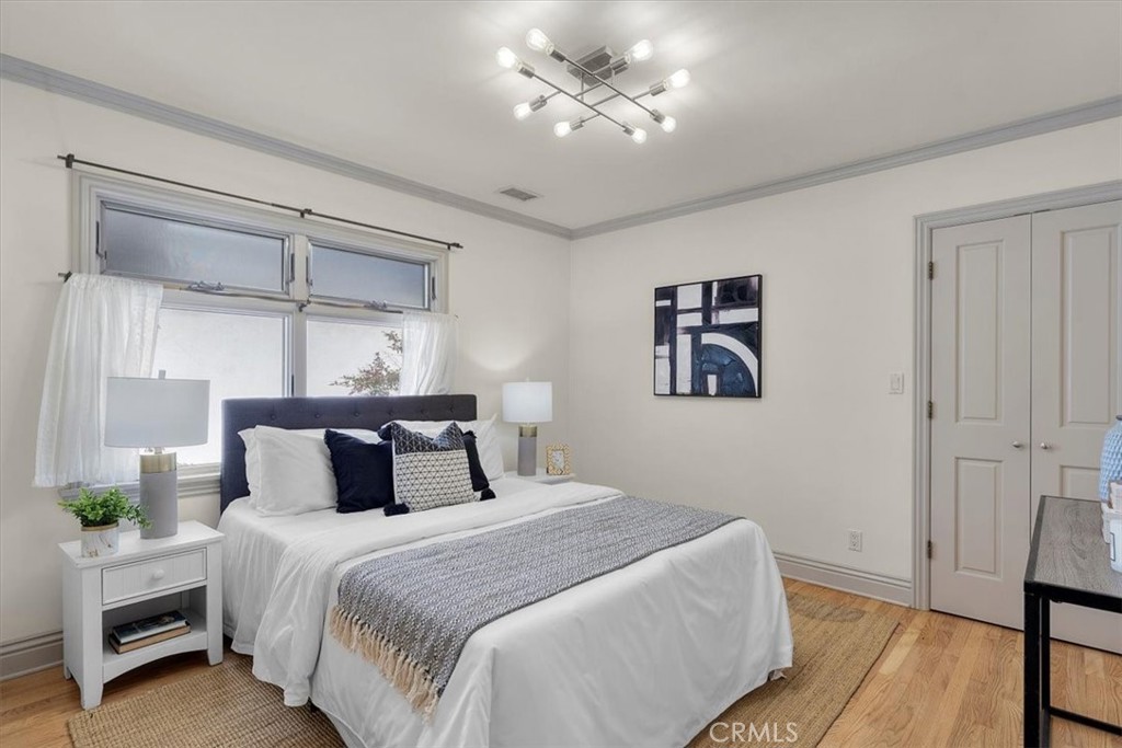 243 Park Avenue Long Beach, CA 90803 - Photo 15 of 52 a bedroom with a large bed and a chandelier