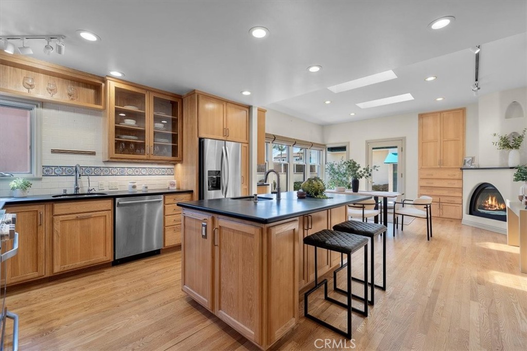 243 Park Avenue Long Beach, CA 90803 - Photo 7 of 52 a kitchen with stainless steel appliances granite countertop wooden floor a stove a sink a refrigerator and chairs
