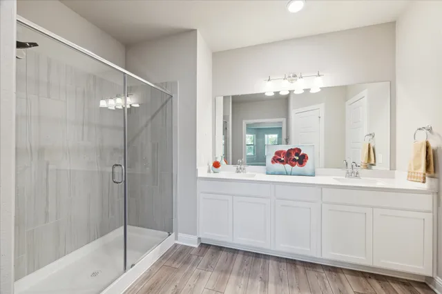 a bathroom with a bathtub shower sink and mirror