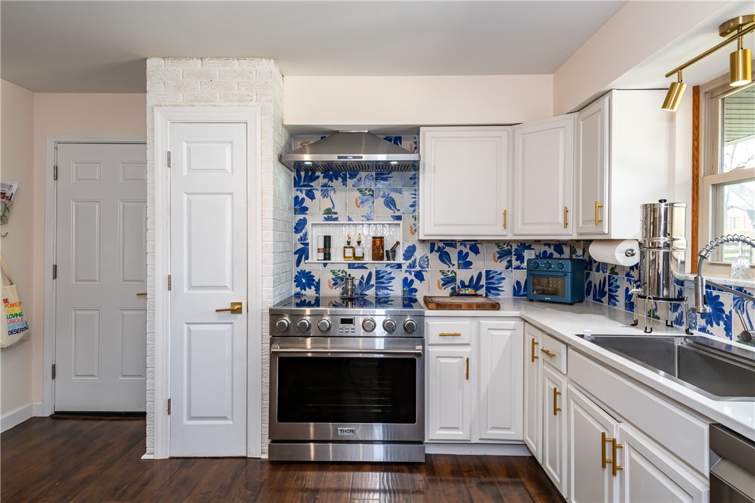 4102 Ridgetop Drive Bellbrook, OH 45305 - Photo 8 of 33 This modern kitchen features a striking blue and white tiled backsplash and ample cabinet space.