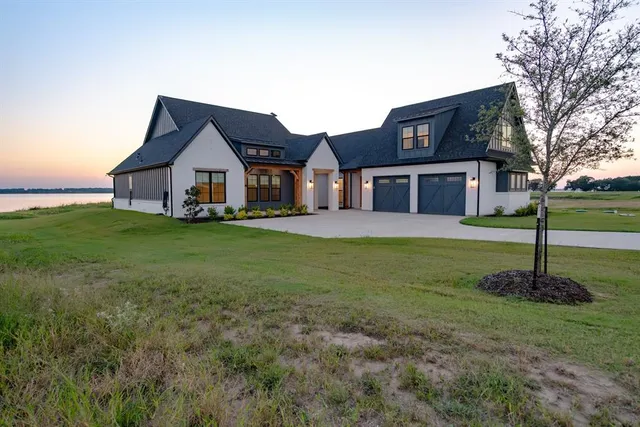 a house that has a big yard with plants and large trees