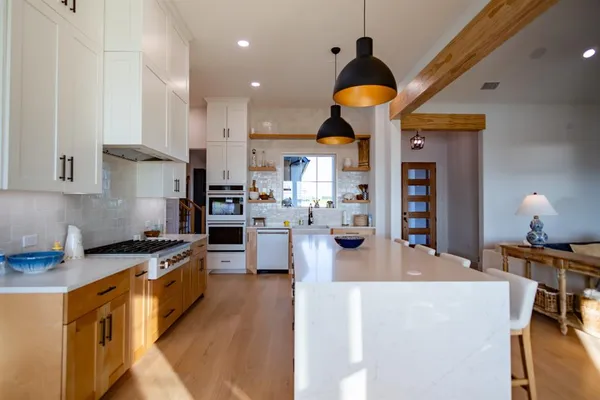 a kitchen with a dining table chairs sink and cabinets