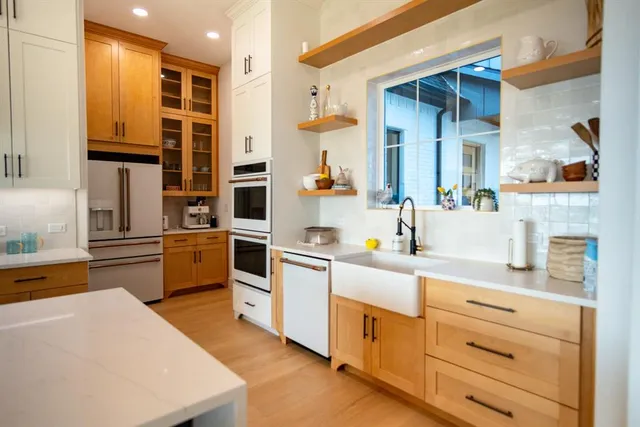a kitchen with stainless steel appliances granite countertop a sink a stove and a refrigerator
