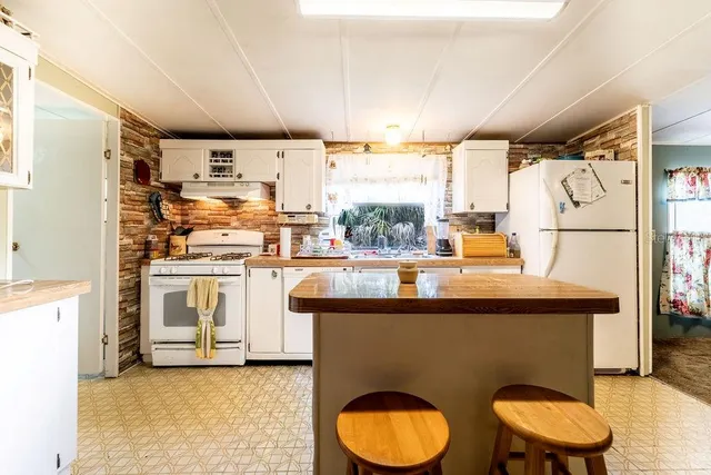a view of a kitchen with stainless steel appliances granite countertop a stove and a sink