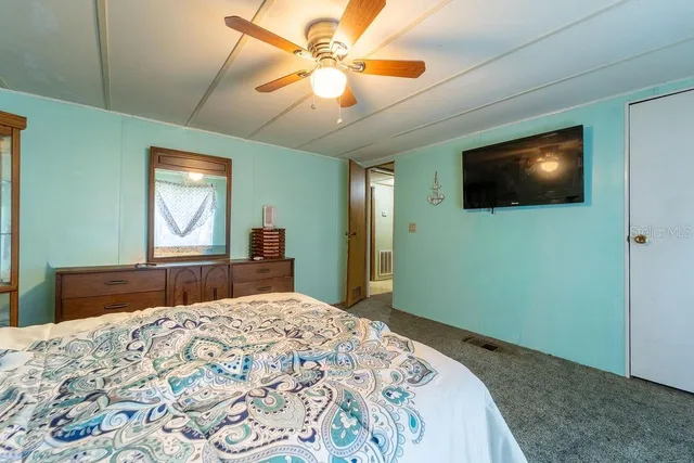 a bedroom with a large bed and a flat screen tv